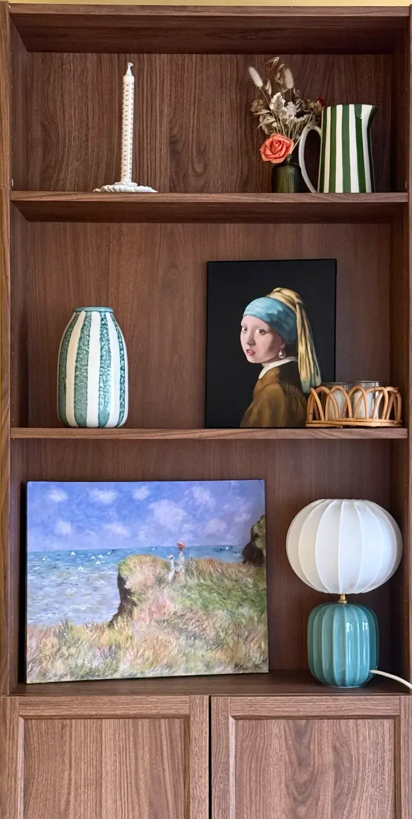 L'étagère de la maison : la Jeune Fille à la perle et la falaise de Monet posées entre deux vases